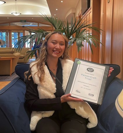 Christine of Castle Coatings holding her PainterCraft Trust certificate