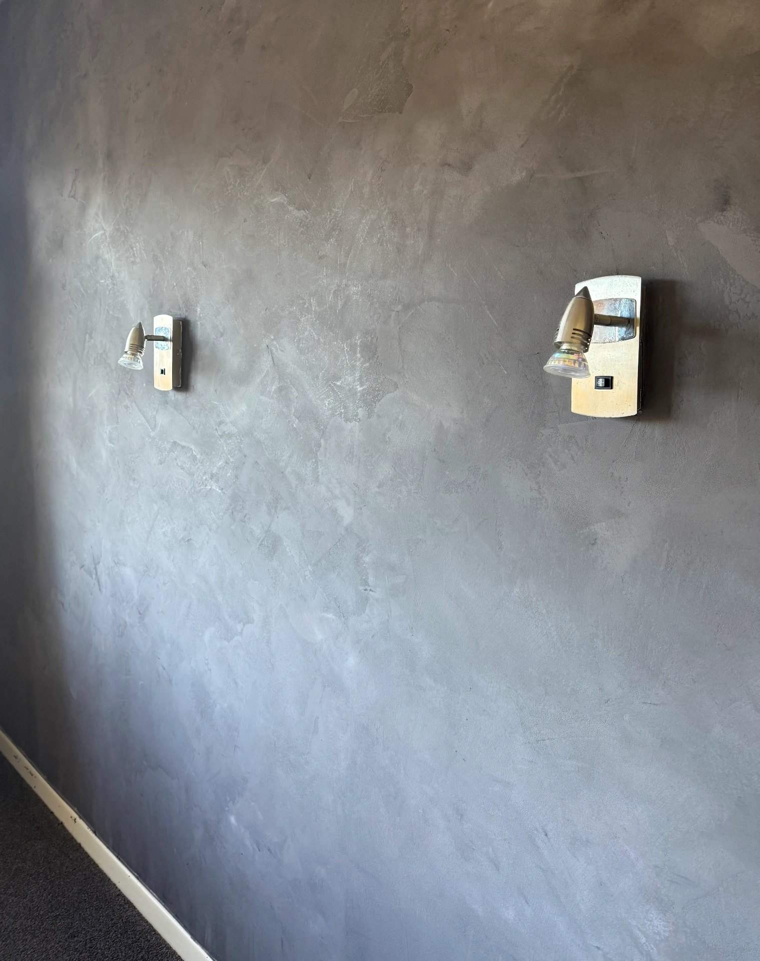 Dark grey Venetian plaster feature wall with wall lights and soft movement